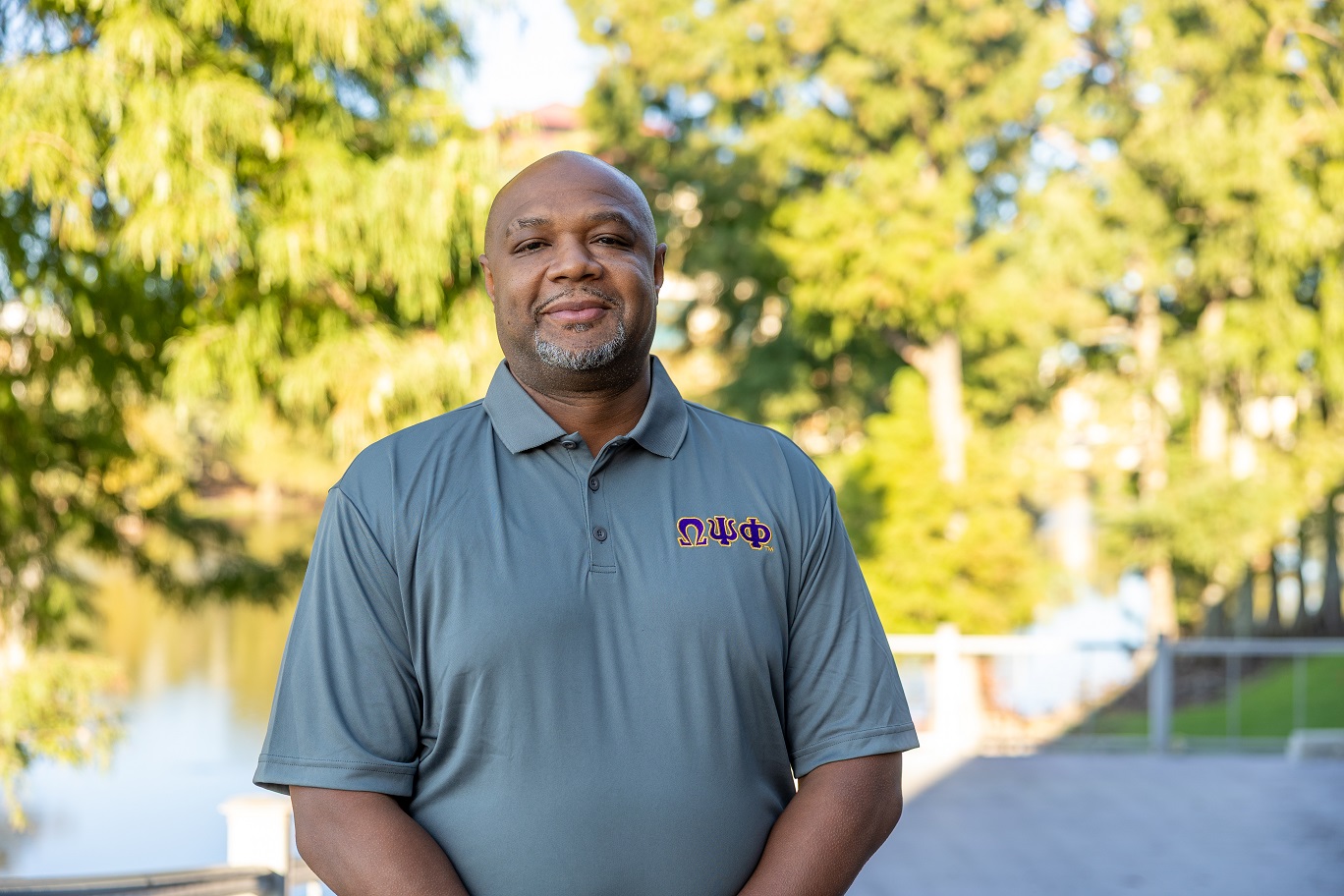 Portrait of Javvi Lewis, ULM Alumni Association Board Member, standing on campus near the bayou.