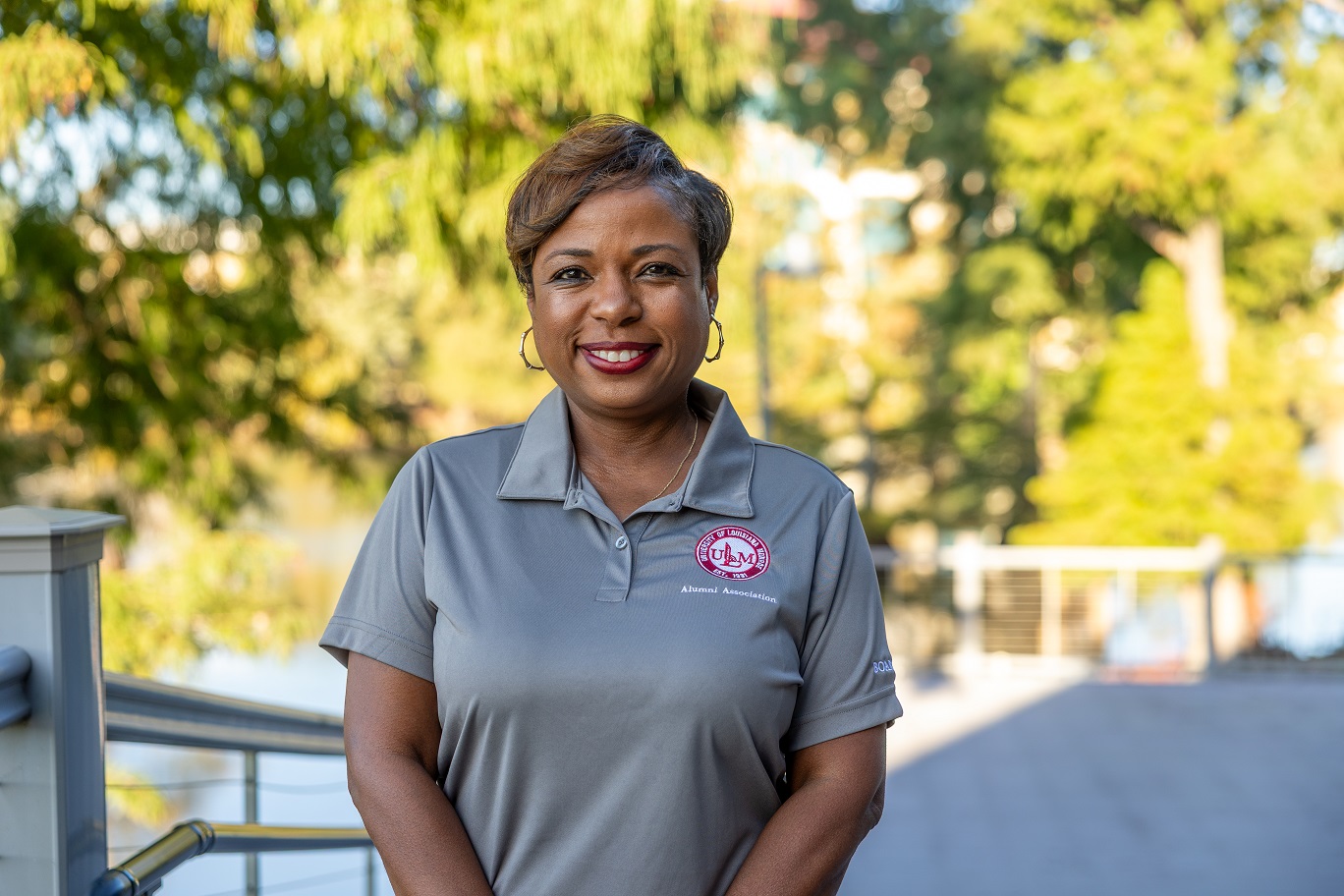 Portrait of Twainna Calhoun, ULM Alumni Association Board Member, standing on campus near the bayou.