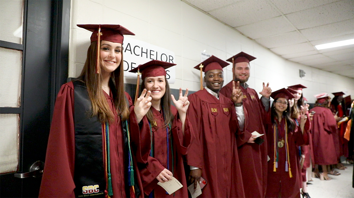 Line Up Students dressed in maroon gowns and caps lined up against the wall in Fant Ewing waiting for the processional