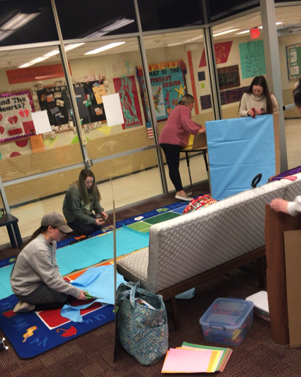 Literacy Lab Students setting up a classroom or educational space, possibly for a project or specialized program.
