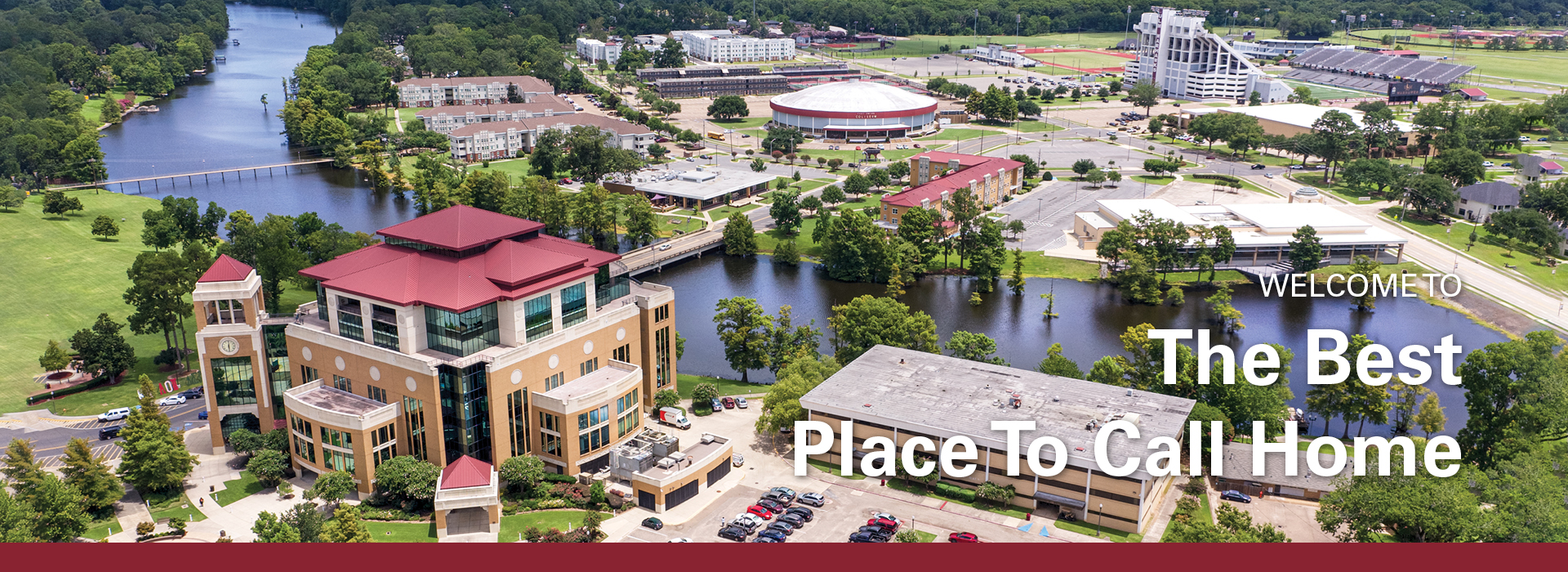 #slide3 University of Louisiana Monroe campus areal view of the Library and the bayou with overlay text: "WELCOME TO The Best Place To Call Home"